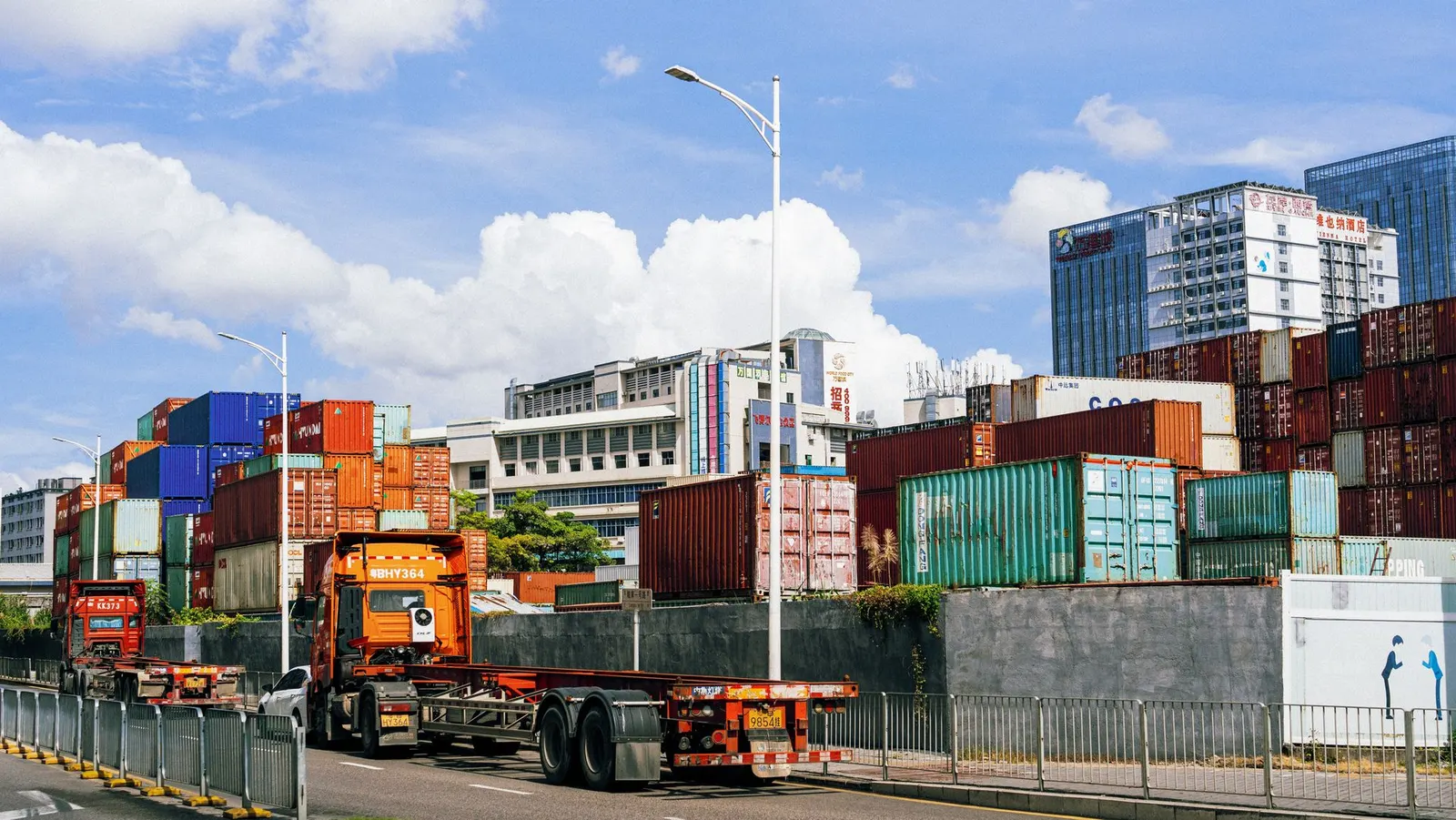 Flatbed truck delivering a 40FT shipping container along a city road