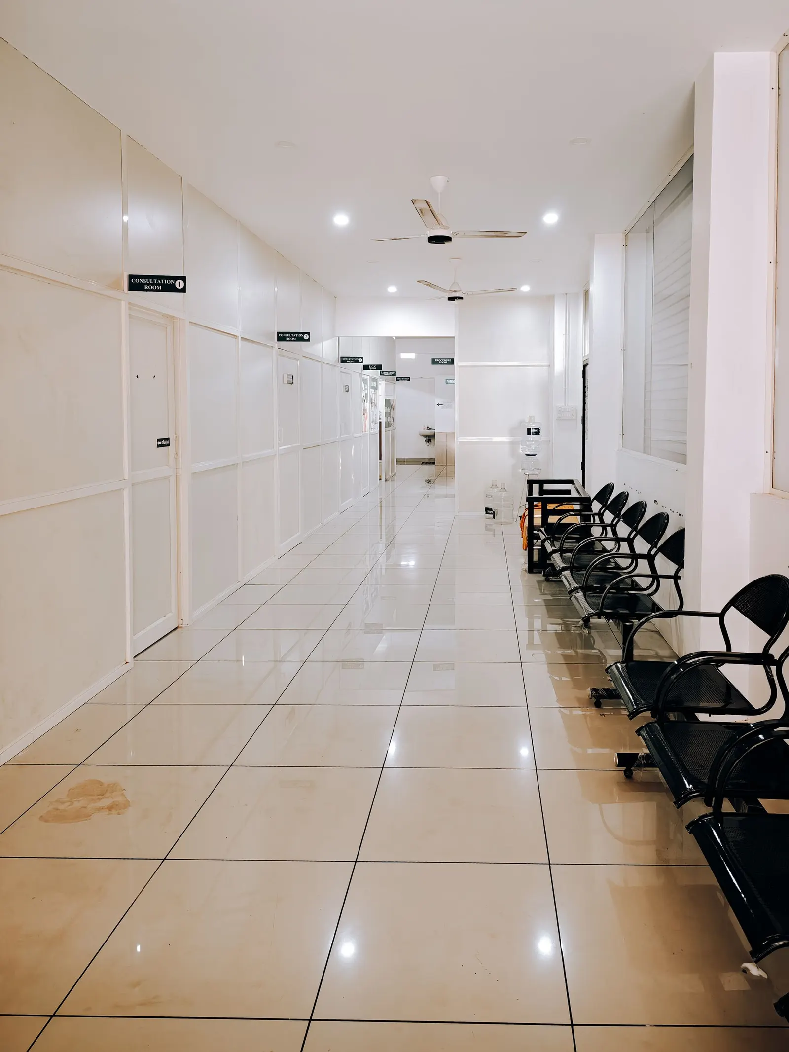 Bright modern hospital corridor with waiting chairs